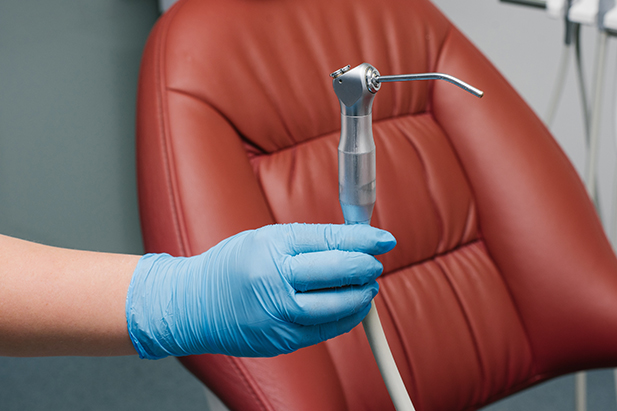 A dentist in Karachi is holding the tool for dental treatment.