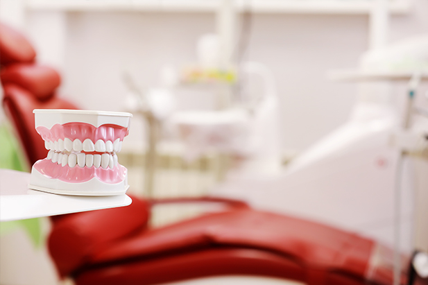 A dental chair and a tooth sample are in the dental clinic in Karachi.