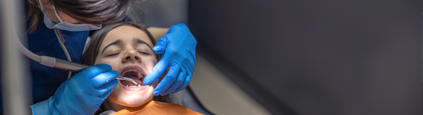 A dentist uses the teeth scaling and polishing tool for tooth cleaning.