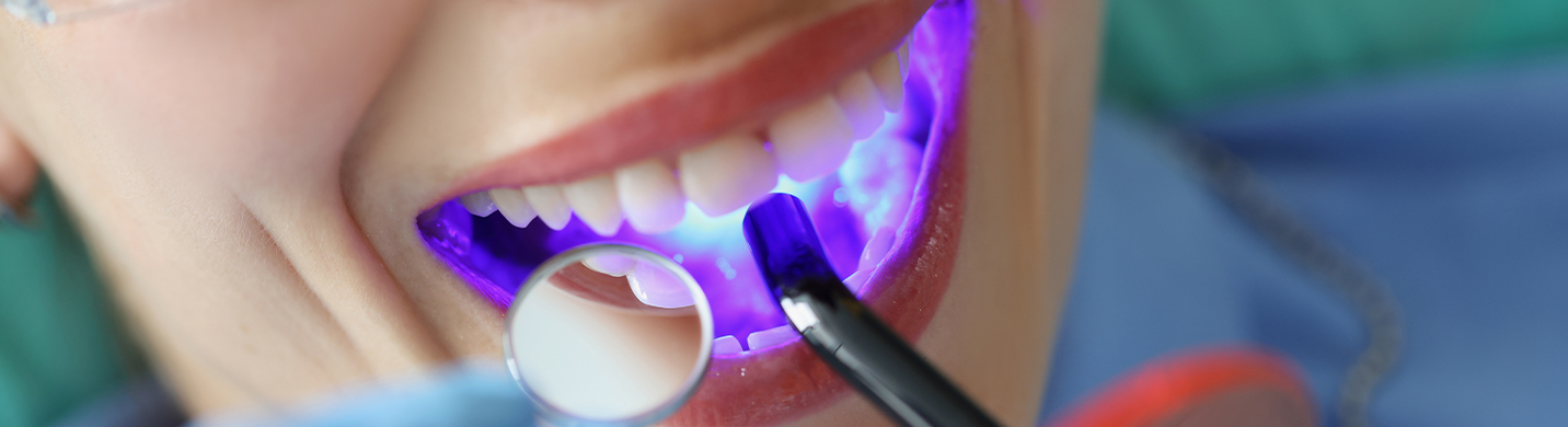 A patient is in front of the dentist having the tooth colored filling.
